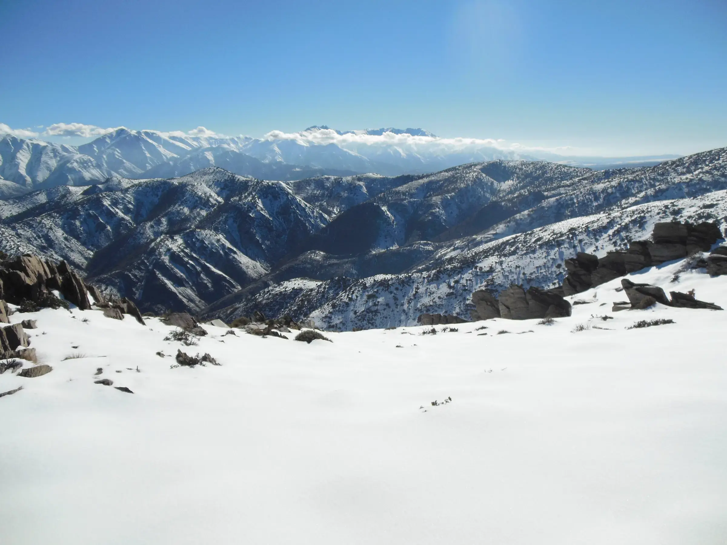 Snow-covered ridges of the High Atlas under a clear blue sky