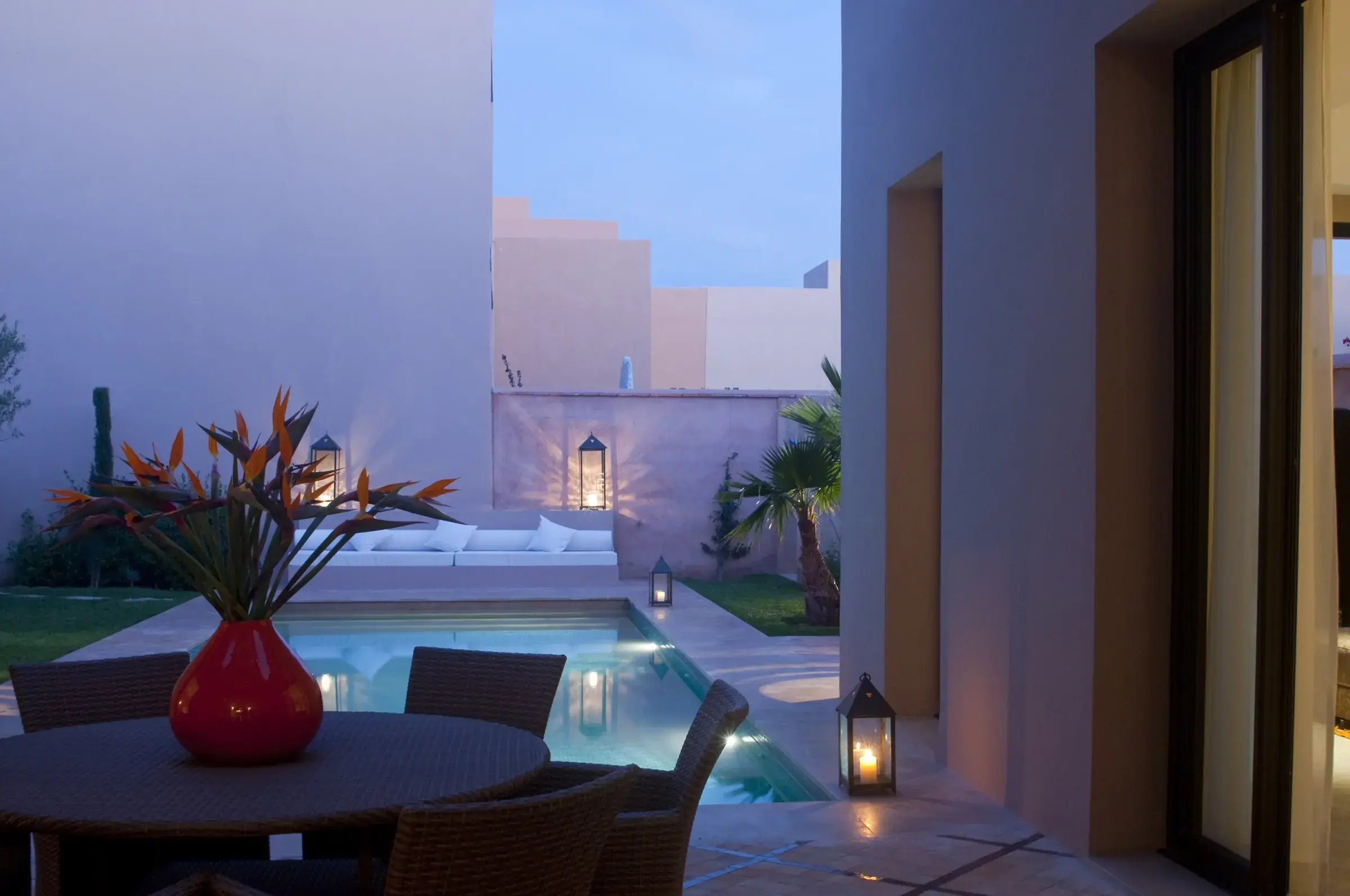 Terraza de una villa contemporánea en Marrakech, piscina iluminada al anochecer